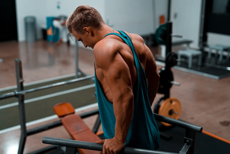 Bodybuilder training push movement tricep dips to stay shredded