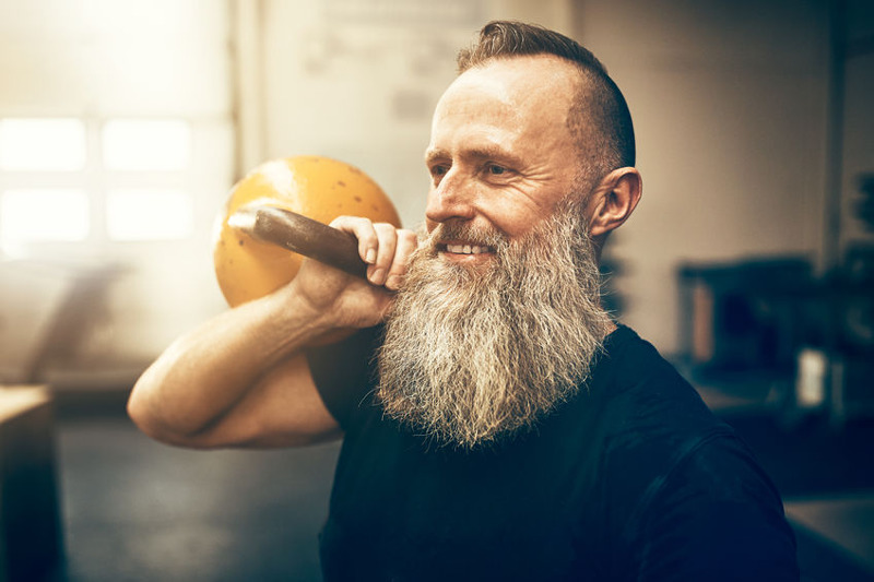 Man over 50 holding kettlebell showing signs of high testosterone