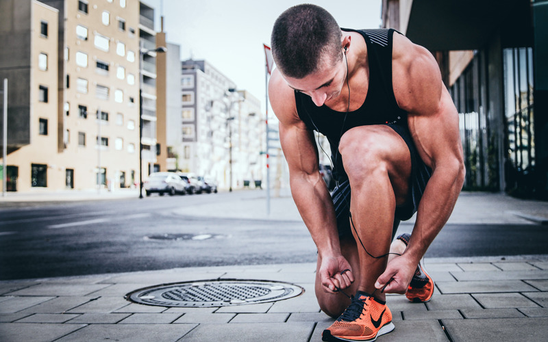 Man lacing up training shoes during fasted cardio for fat loss